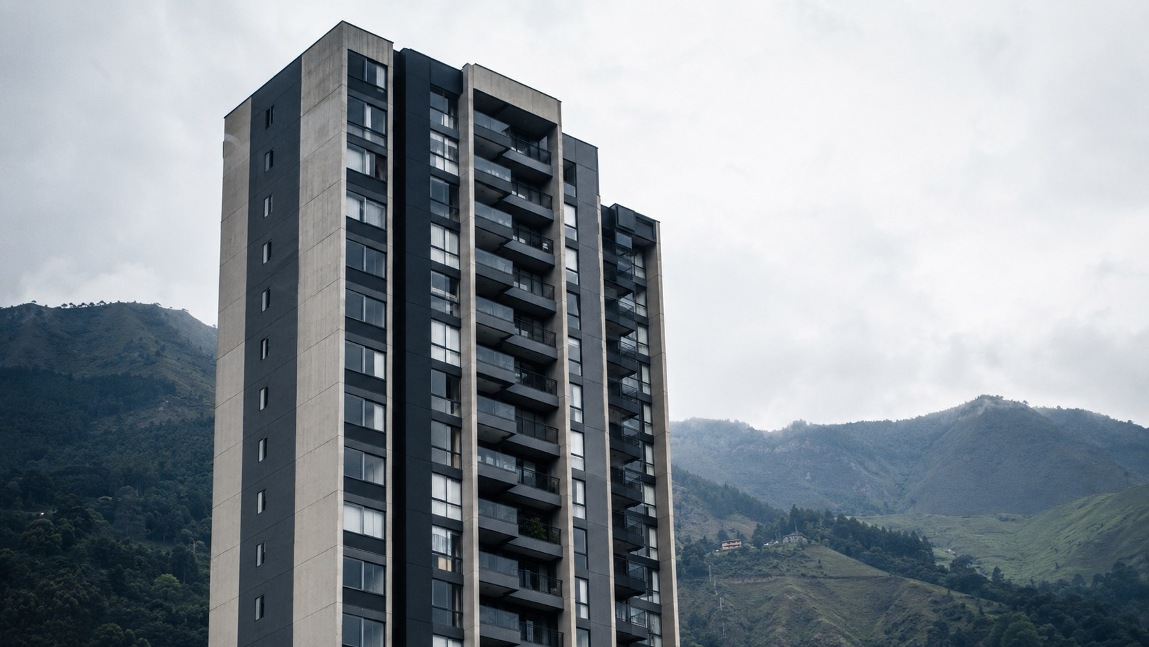 Modern apartment tower against the green slopes of the Aburrá Valley, Medellín
